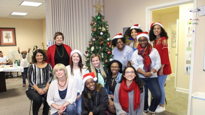 DLC students and staff posing in front of a Christmas tree